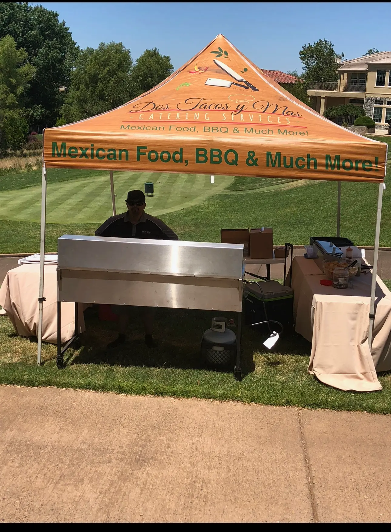 Dos Tacos Y Mas branded canopy and grill station set up at an outdoor pop-up event